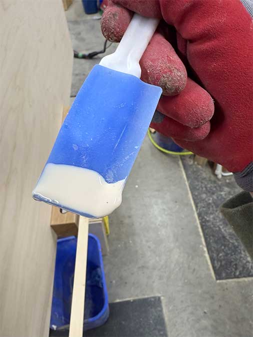 Closeup showing dried glue peeling off a spatula for easy cleanup